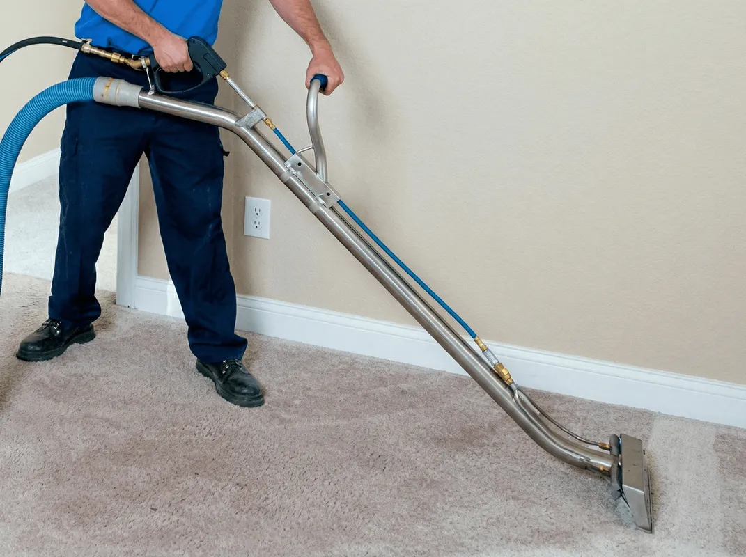 Professional operating a liquid removal machine on a carpeted floor in Milwaukee, WI